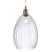 Clear glass pendant light with brass fixture on a white background