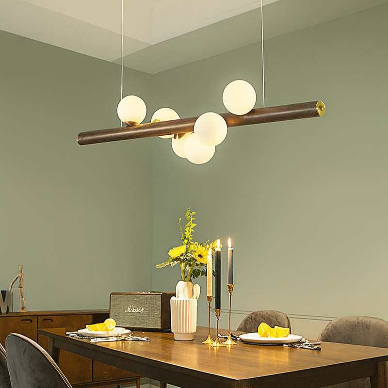 Dining room with a modern pendant light fixture, wooden table, and chairs.