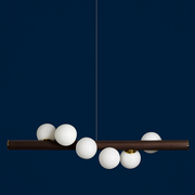 Modern chandelier with white spherical lights on a dark blue background