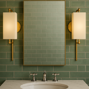 Bathroom vanity with mirror, sink, and wall lights against a green tiled wall.
